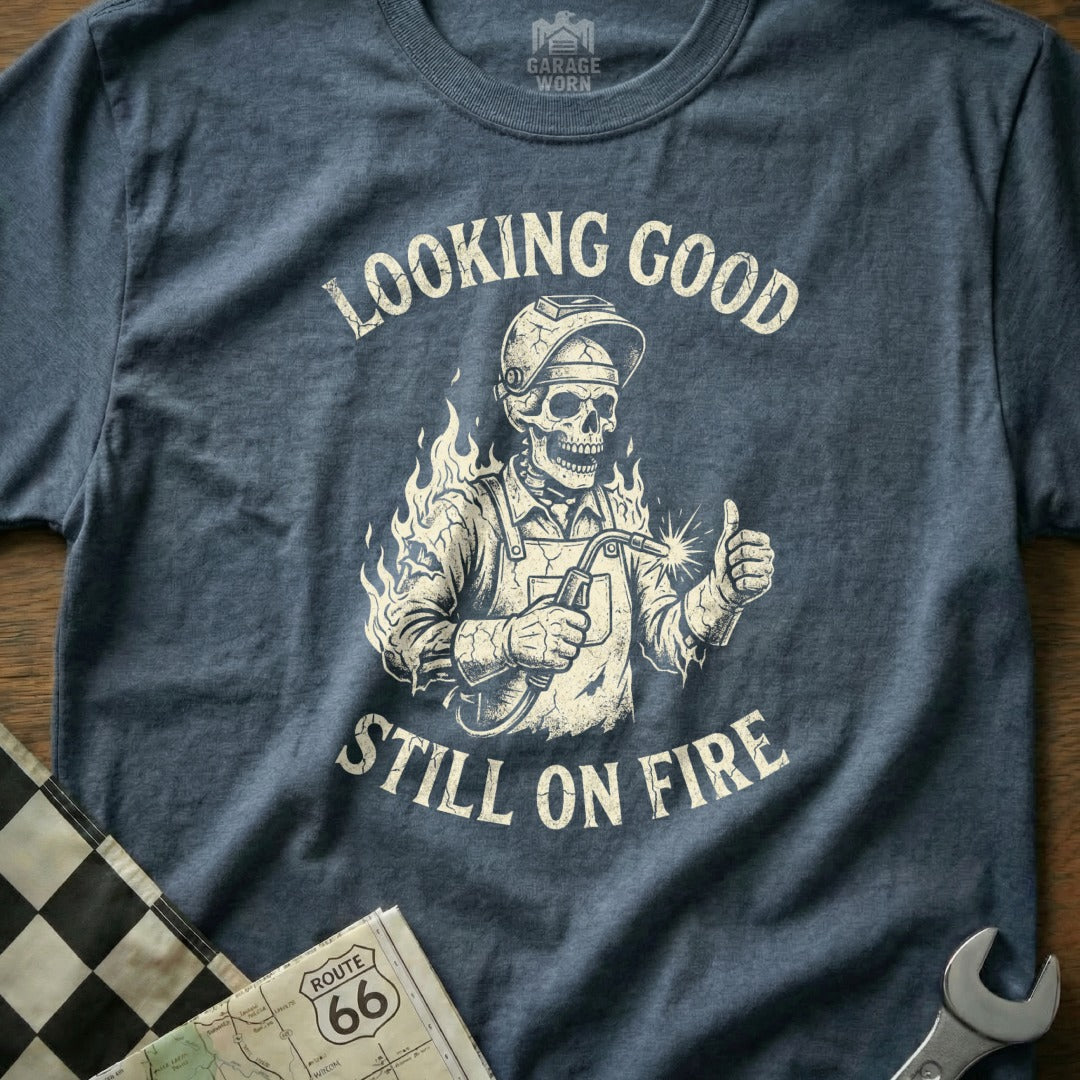Skeleton welder giving thumbs up with "Looking Good Still On Fire" text.