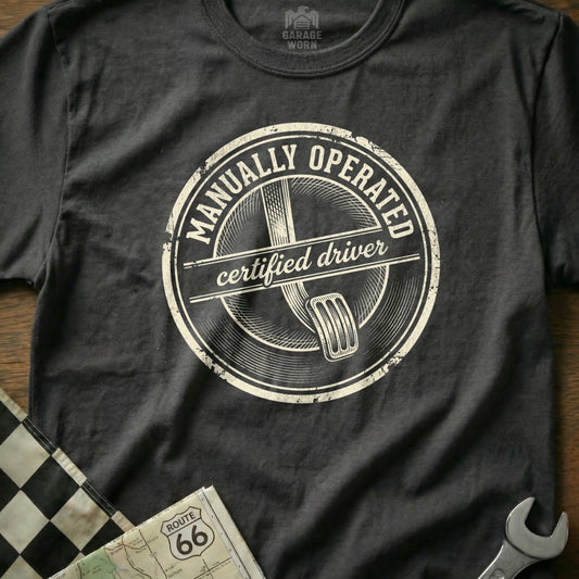 T-shirt with "MANUALLY OPERATED certified driver" circular graphic.