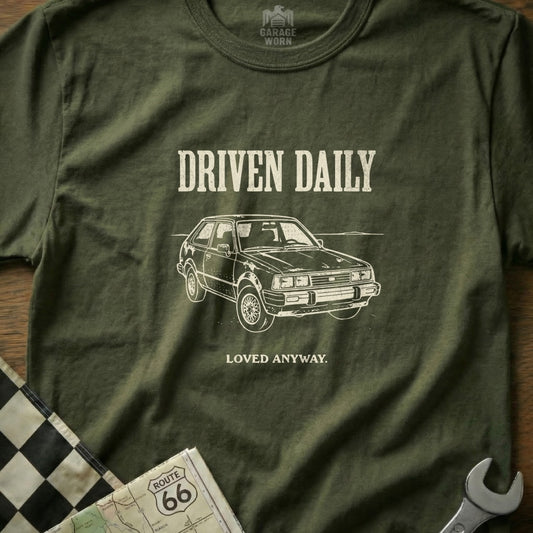 Olive t-shirt with "Driven Daily" and a car illustration.