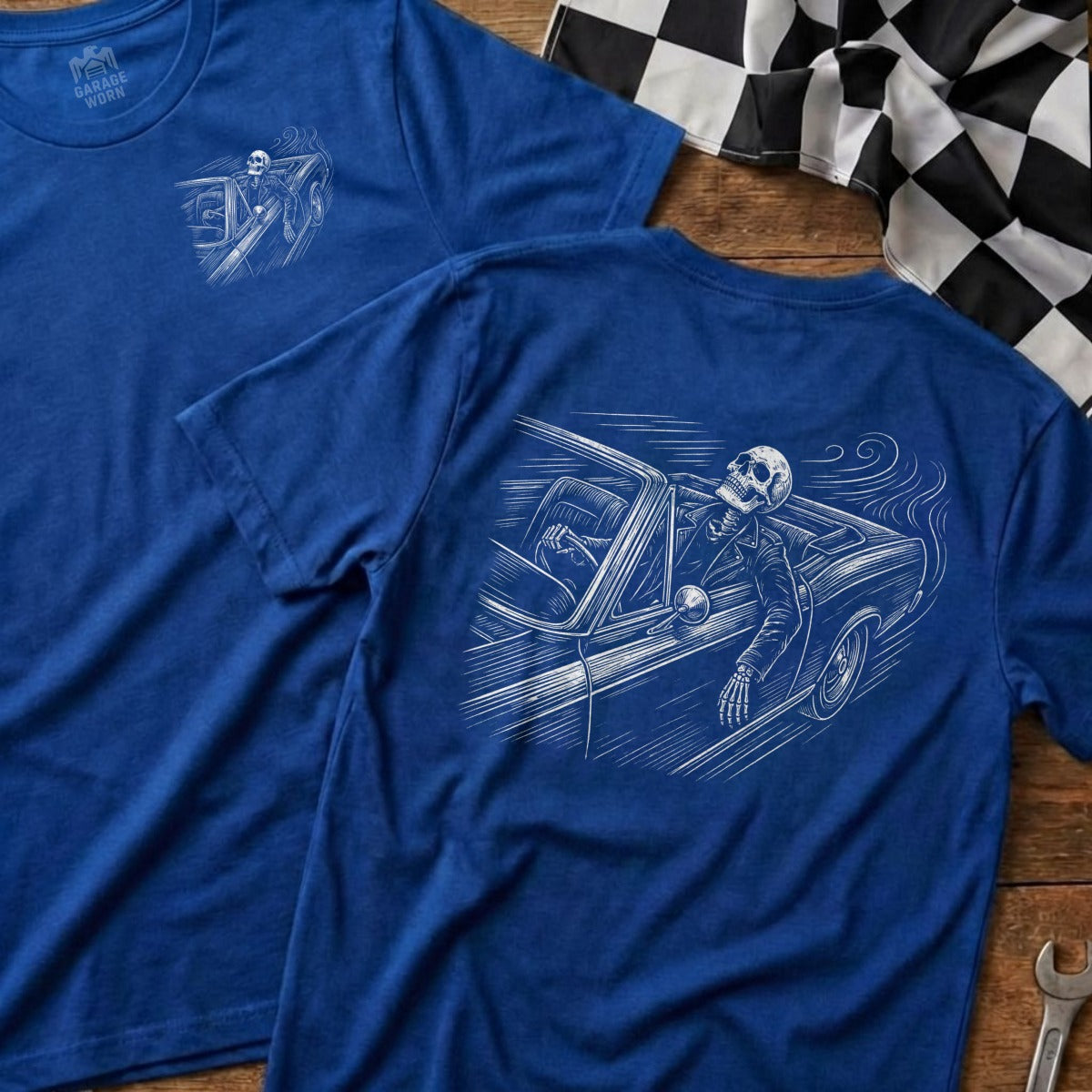 Two blue t-shirts with skeleton driving a car graphic.