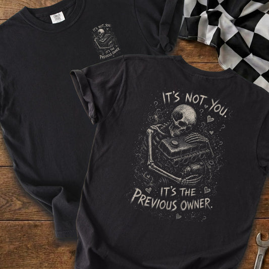 Black t-shirt with skeleton holding engine, "It's not you. It's the previous owner."