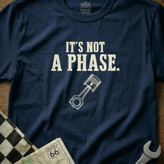Navy t-shirt with white text "It's not a phase." and a piston graphic.