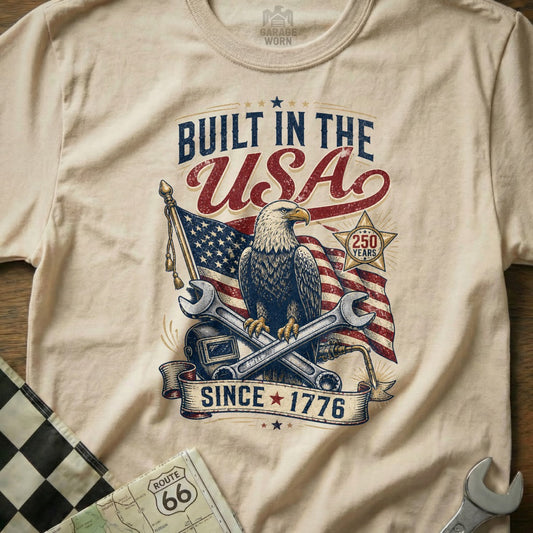 T-shirt graphic with eagle, USA flag, tools, and text "Built in the USA Since 1776".
