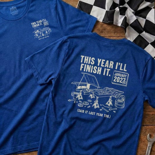 Blue t-shirt with "This Year I'll Finish It" and car on jacks.