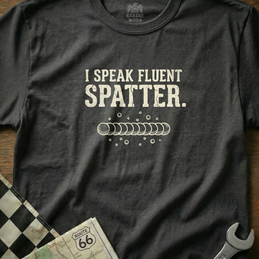 T-shirt with "I Speak Fluent Spatter." text and welding bead graphic.