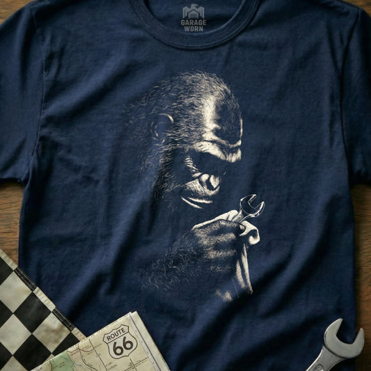 Monkey holding a wrench on a navy t-shirt with "Garage Worn" logo.