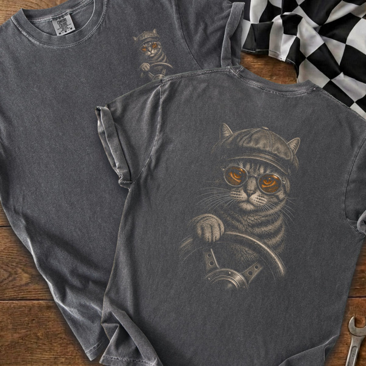 Dark grey t-shirt with graphic of a cat wearing a cap and glasses, driving a car.