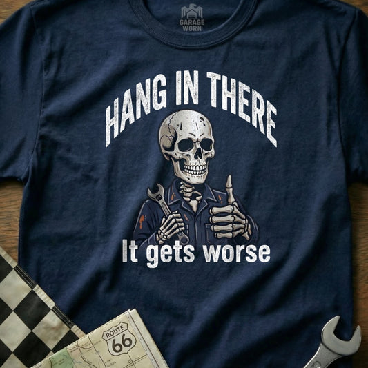 Skeleton mechanic giving thumbs up, wearing "Hang in There It Gets Worse" shirt.