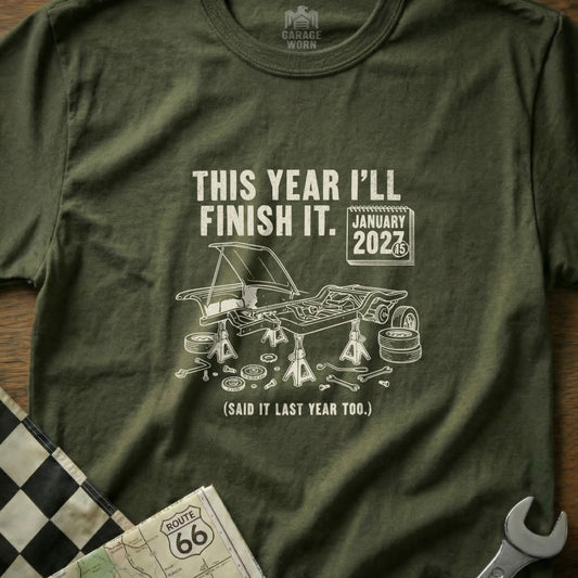 Olive green t-shirt with "This Year I'll Finish It. January 2027" and car graphic.