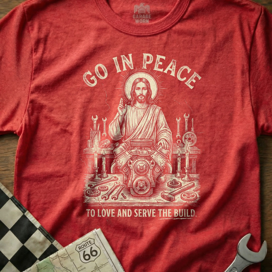 Red t-shirt with Jesus working on an engine, "Go In Peace" and "To Love And Serve The Build."