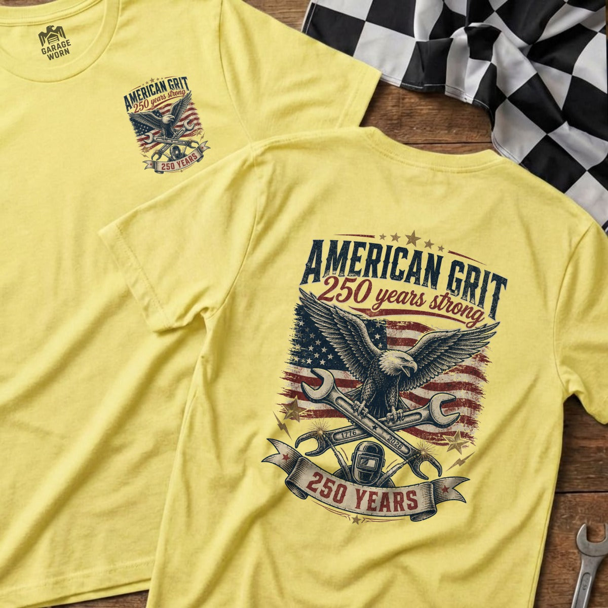 Yellow t-shirt featuring an eagle, wrenches, and American flag with "American Grit 250 Years Strong" text.