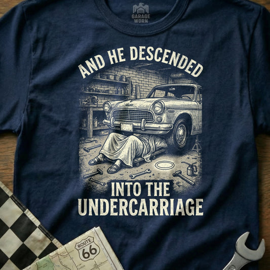 Man in robe working on car undercarriage, text reads "And He Descended Into The Undercarriage".
