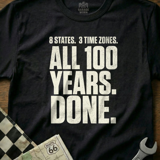 Black t-shirt with "8 States. 3 Time Zones. All 100 Years. Done." text.