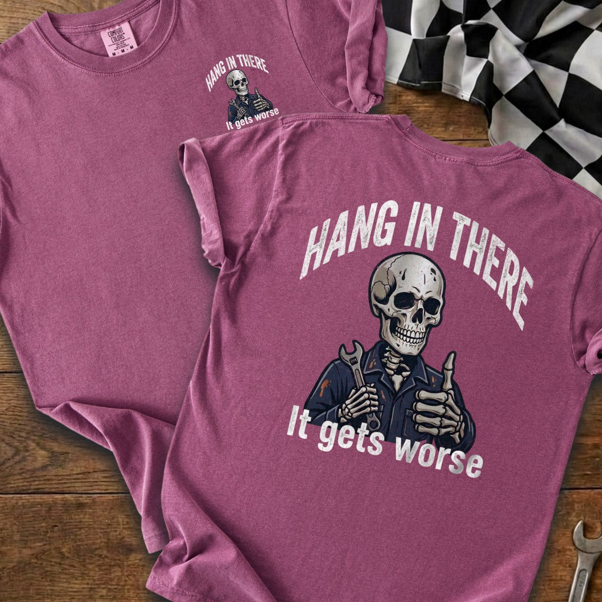 Two plum t-shirts with a skeleton graphic and "Hang in There" text.