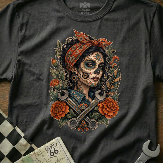 T-shirt graphic featuring a woman in Day of the Dead makeup with wrenches and flowers.
