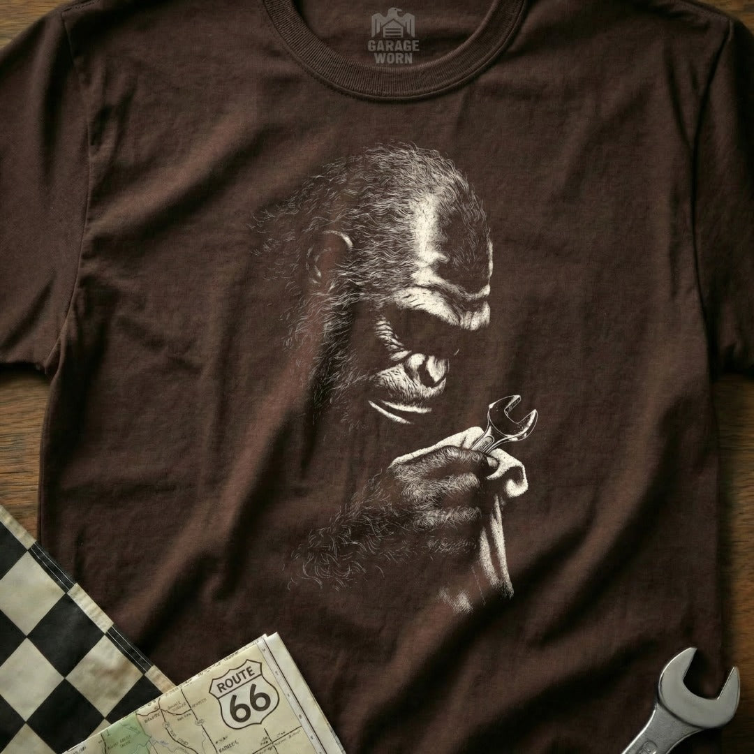 Brown t-shirt with a line drawing of a gorilla holding a wrench.
