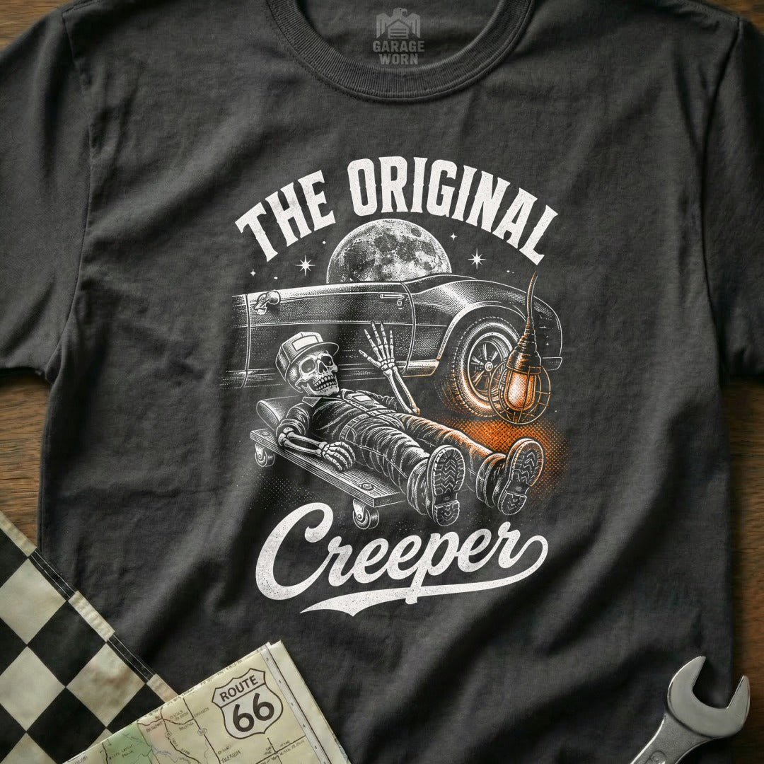 T-shirt graphic with skeleton on creeper under car, "The Original Creeper" text.