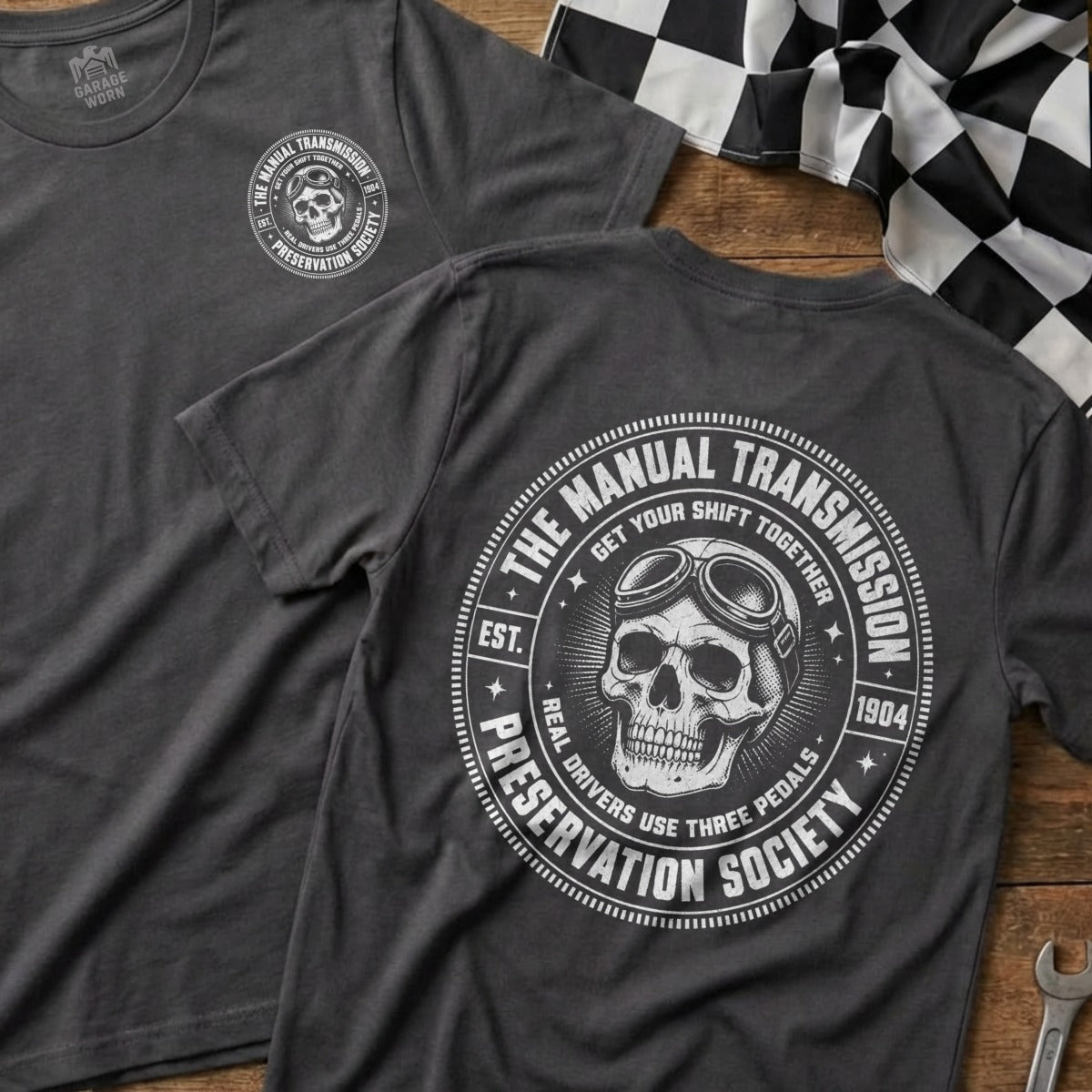 Grey t-shirt with "Manual Transmission Preservation Society" skull logo and racing flag.