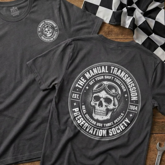 Grey t-shirt with "Manual Transmission Preservation Society" skull logo and racing flag.