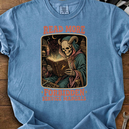 T-shirt with a horned skeleton reading a book titled "Forbidden Service Manuals" with "Read More" text.
