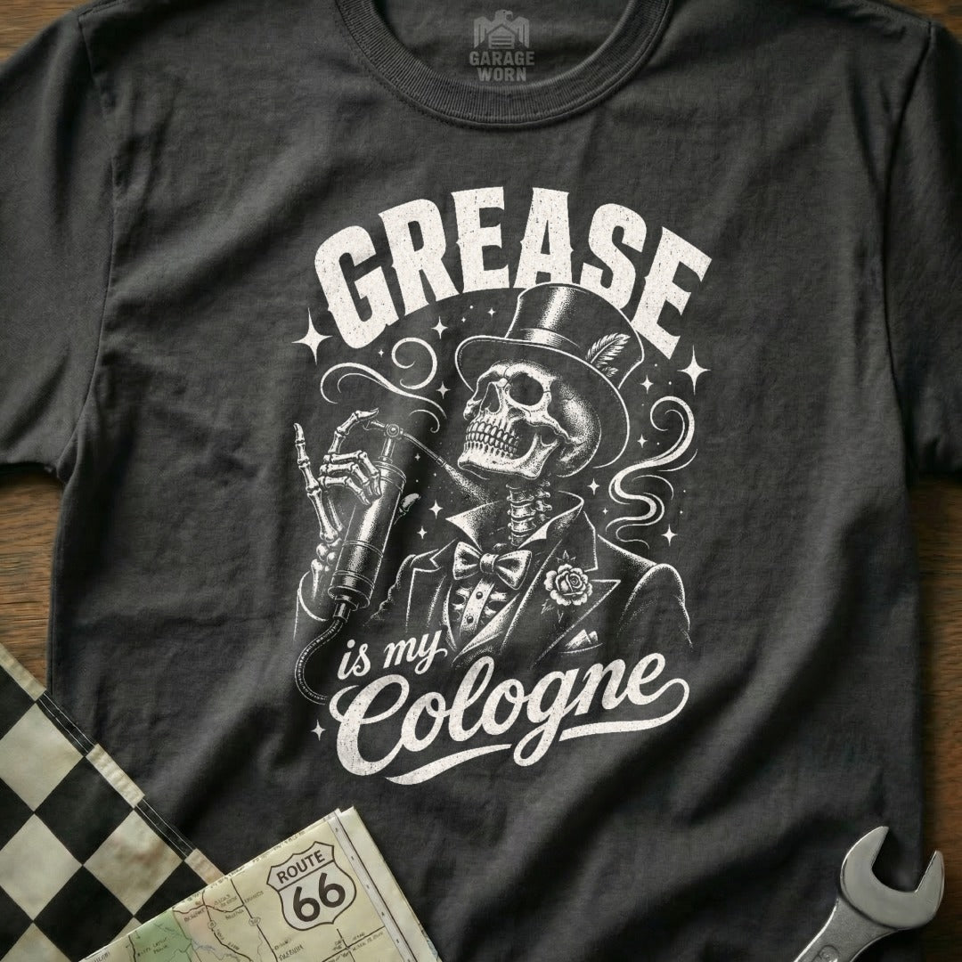 Dark t-shirt with graphic of skeleton in tuxedo with hat, holding spray bottle, reading "GREASE is my Cologne".