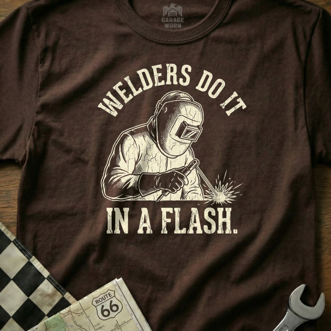 Brown t-shirt with graphic of a welder and text "Welders Do It In A Flash."