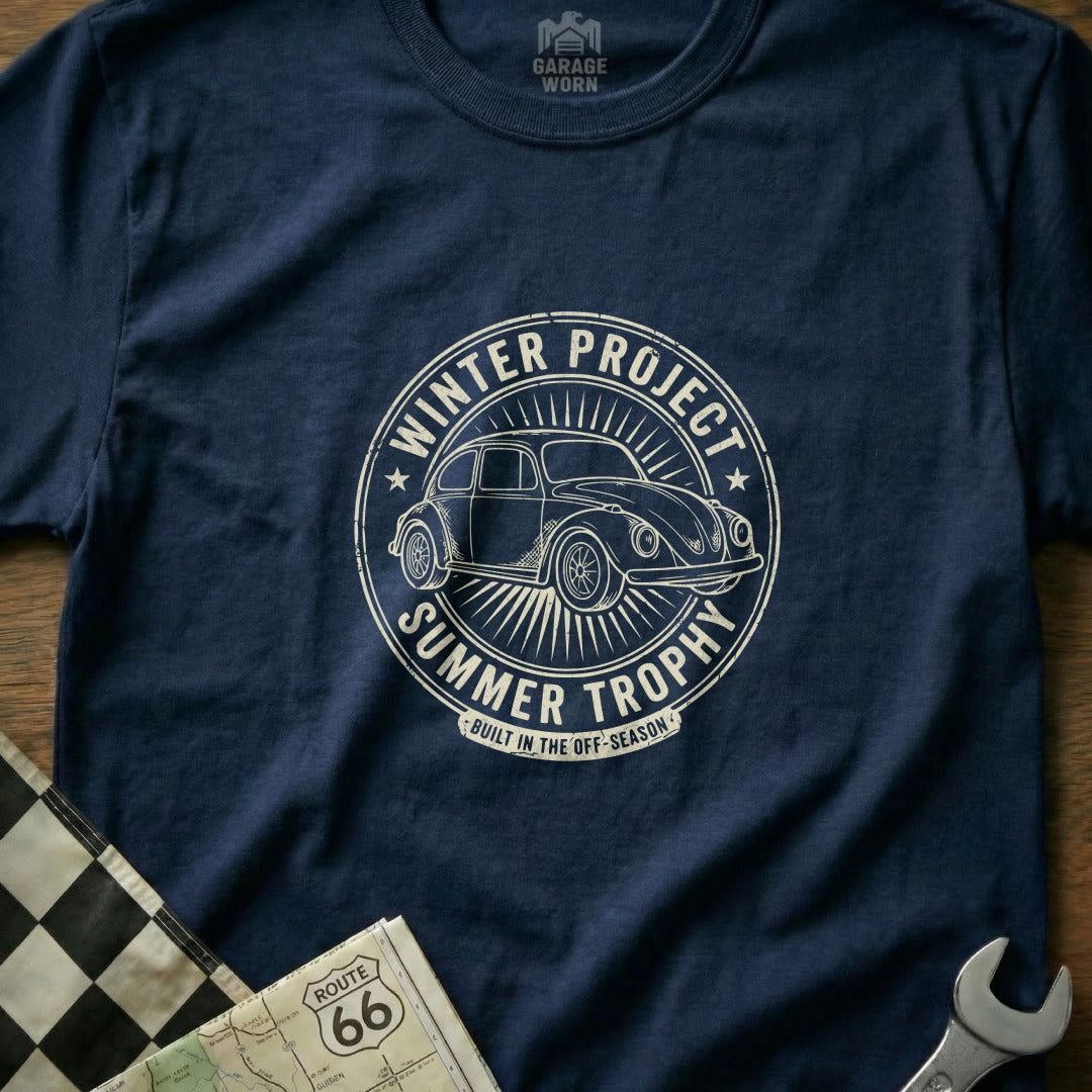 Navy t-shirt with circular graphic of a Volkswagen Beetle, "Winter Project Summer Trophy" text.