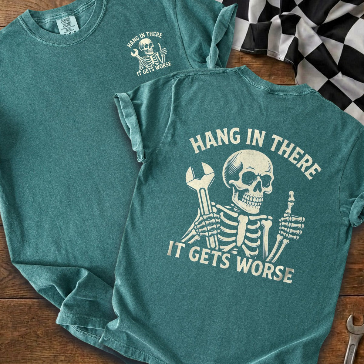 Teal t-shirt with distressed skeleton graphic holding a wrench and giving a thumbs-up.
