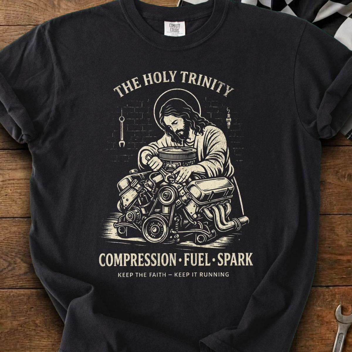Jesus working on an engine with text "The Holy Trinity, Compression, Fuel, Spark."