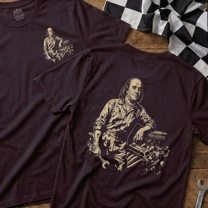 Benjamin Franklin depicted as a mechanic with engine and tools on t-shirt.