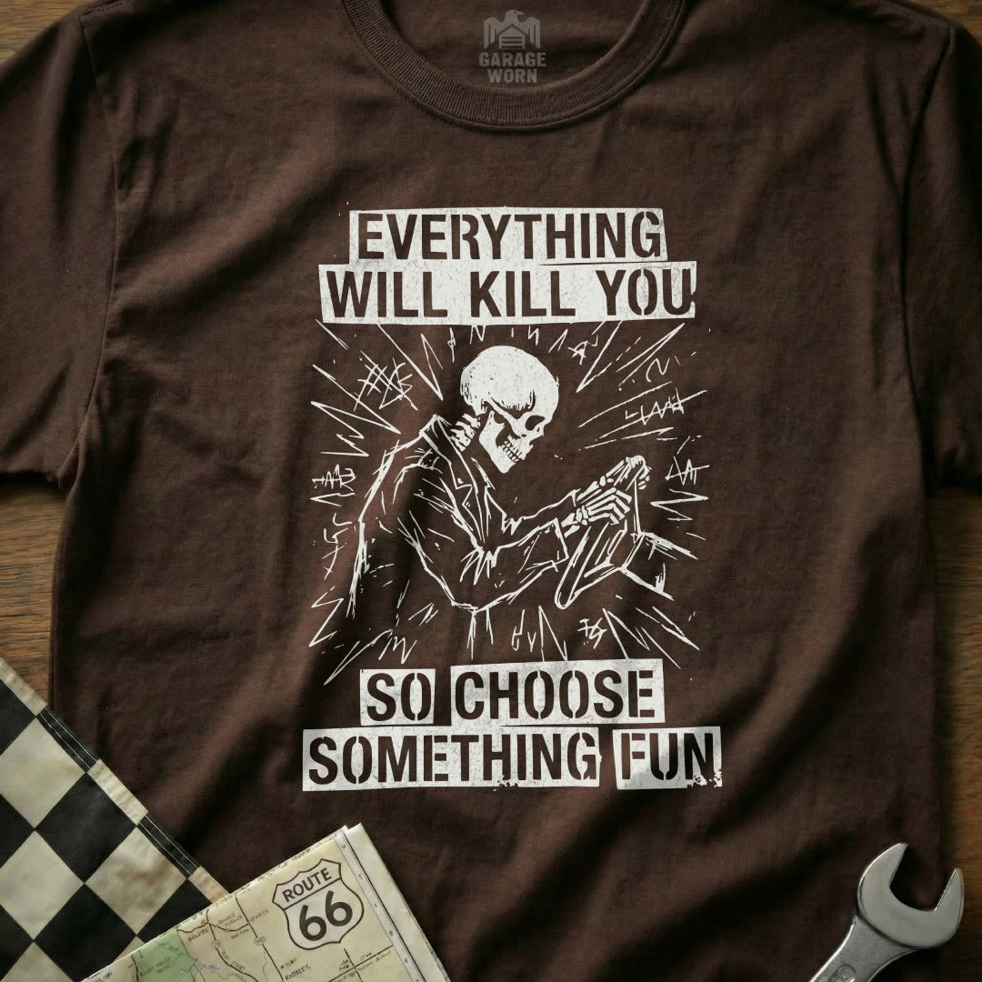 Brown t-shirt with graphic of skeleton driving, "Everything will kill you so choose something fun."