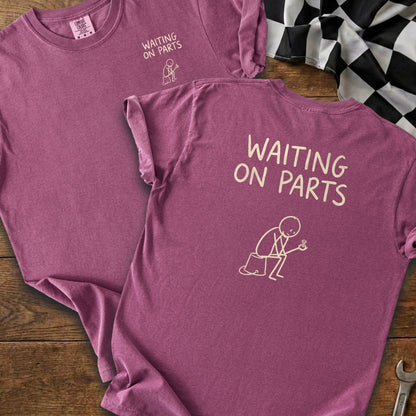 Purple t-shirt with "WAITING ON PARTS" text and a stick figure holding a bolt.