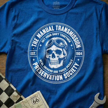 Blue shirt with a white circular graphic of a skull wearing goggles and text.