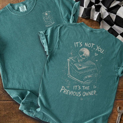Teal t-shirt with skeleton holding engine graphic and text "It's not you. It's the previous owner."