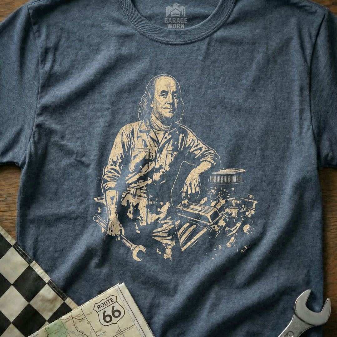 Benjamin Franklin in mechanic's overalls, leaning on an engine with tools.