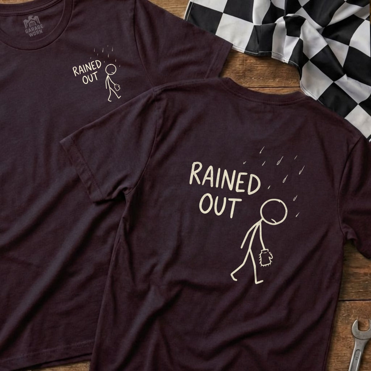 Two dark t-shirts with "RAINED OUT" text and a stick figure under raindrops.