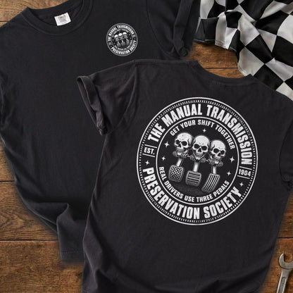 Black t-shirt with "The Manual Transmission Preservation Society" graphic featuring skulls and pedals.