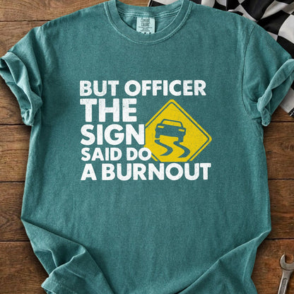 Teal t-shirt with white text and a yellow slippery road sign depicting a car.