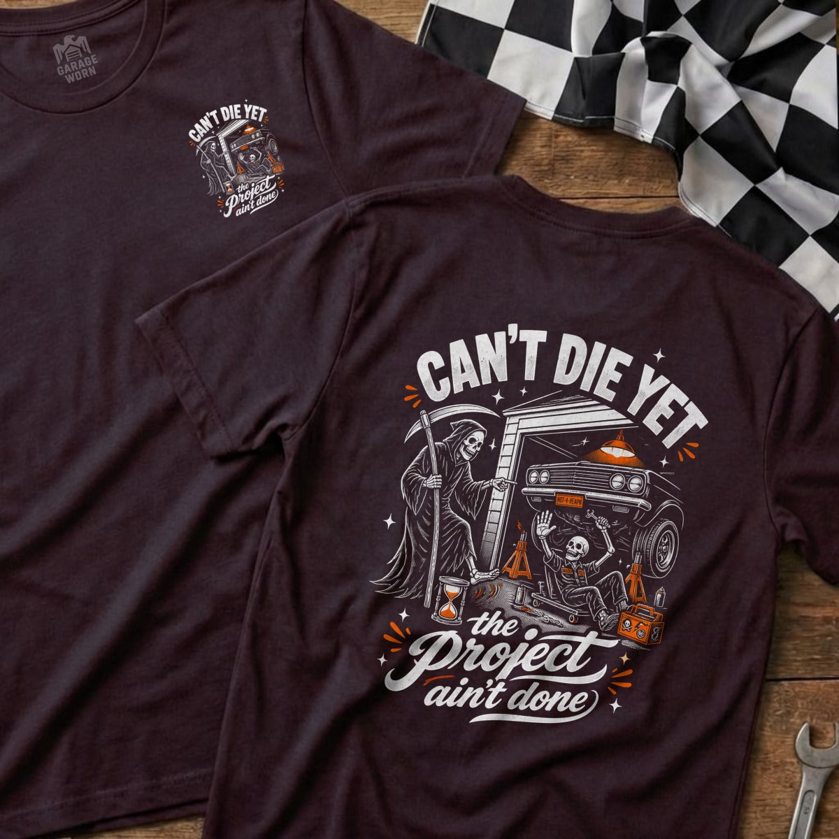 T-shirt with Grim Reaper, skeleton, and car graphic, reads "Can't Die Yet, The Project Ain't Done."