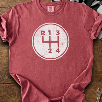 Red t-shirt with a distressed white circle graphic of a manual gear shift pattern.