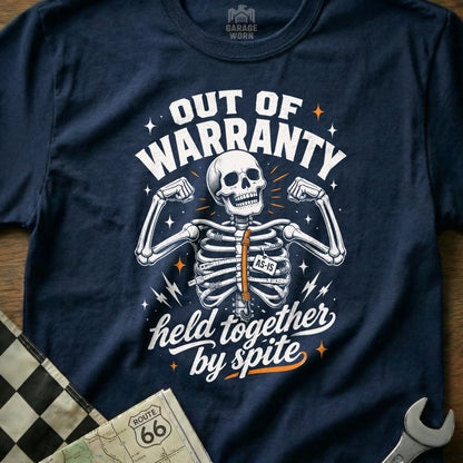 Navy t-shirt with skeleton graphic reading "Out of Warranty, Held Together by Spite".