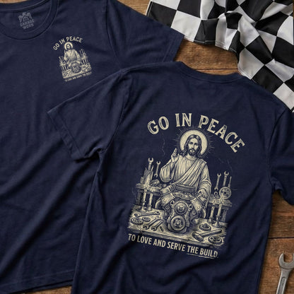 Navy t-shirt with Jesus working on an engine, text "GO IN PEACE TO LOVE AND SERVE THE BUILD".