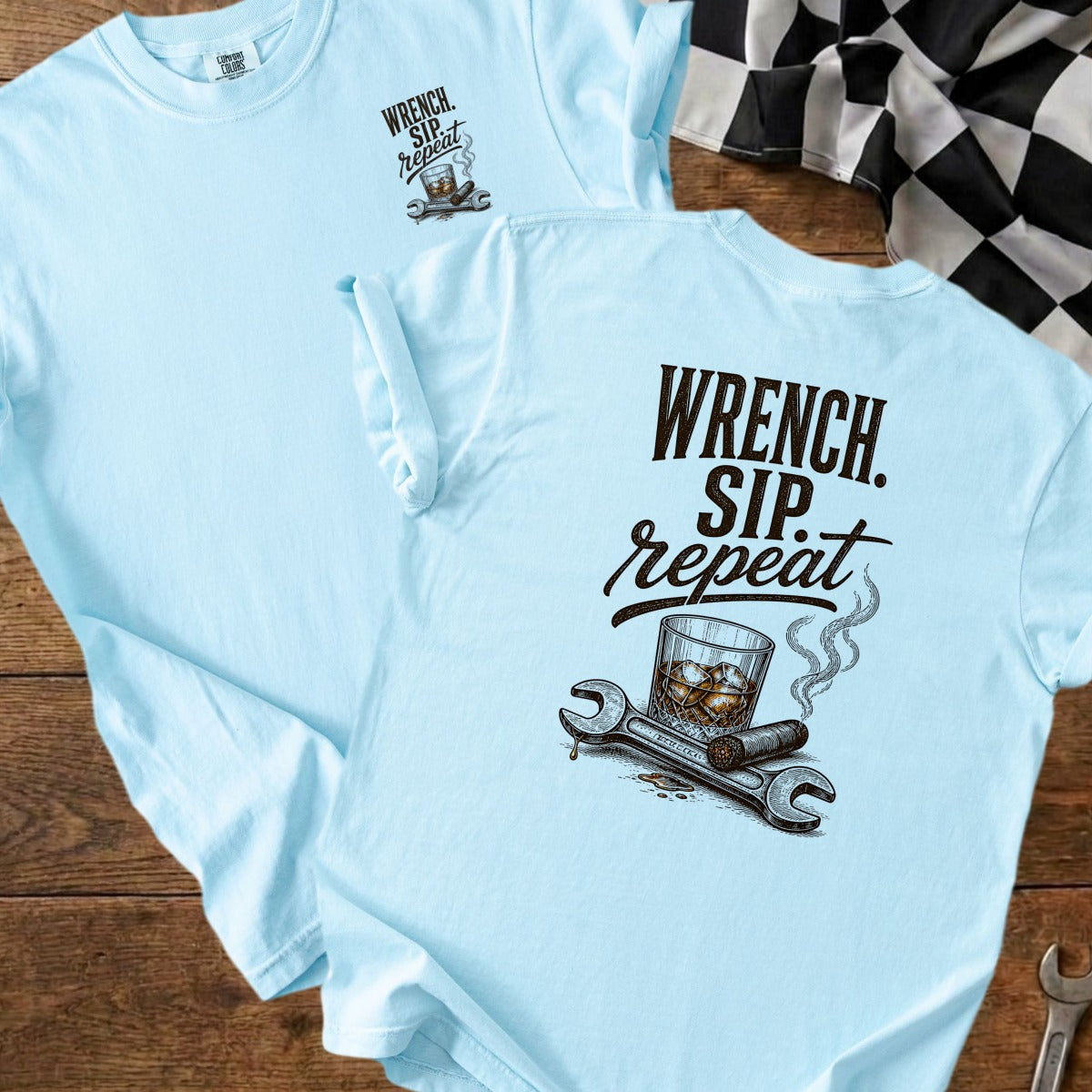 Light blue t-shirt with "Wrench. Sip. Repeat." graphic and wrenches.