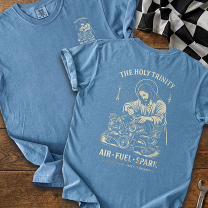 Blue t-shirt with "The Holy Trinity" graphic of Jesus working on an engine.