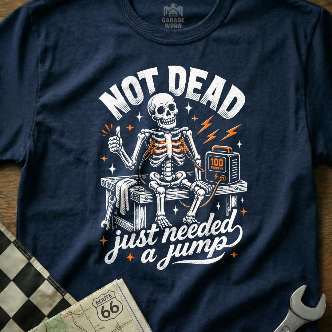 Skeleton sitting on a workbench, connected to a jump starter, with text "NOT DEAD just needed a jump".