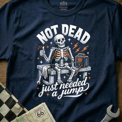 Skeleton sitting on a workbench, connected to a jump starter, with text "NOT DEAD just needed a jump".