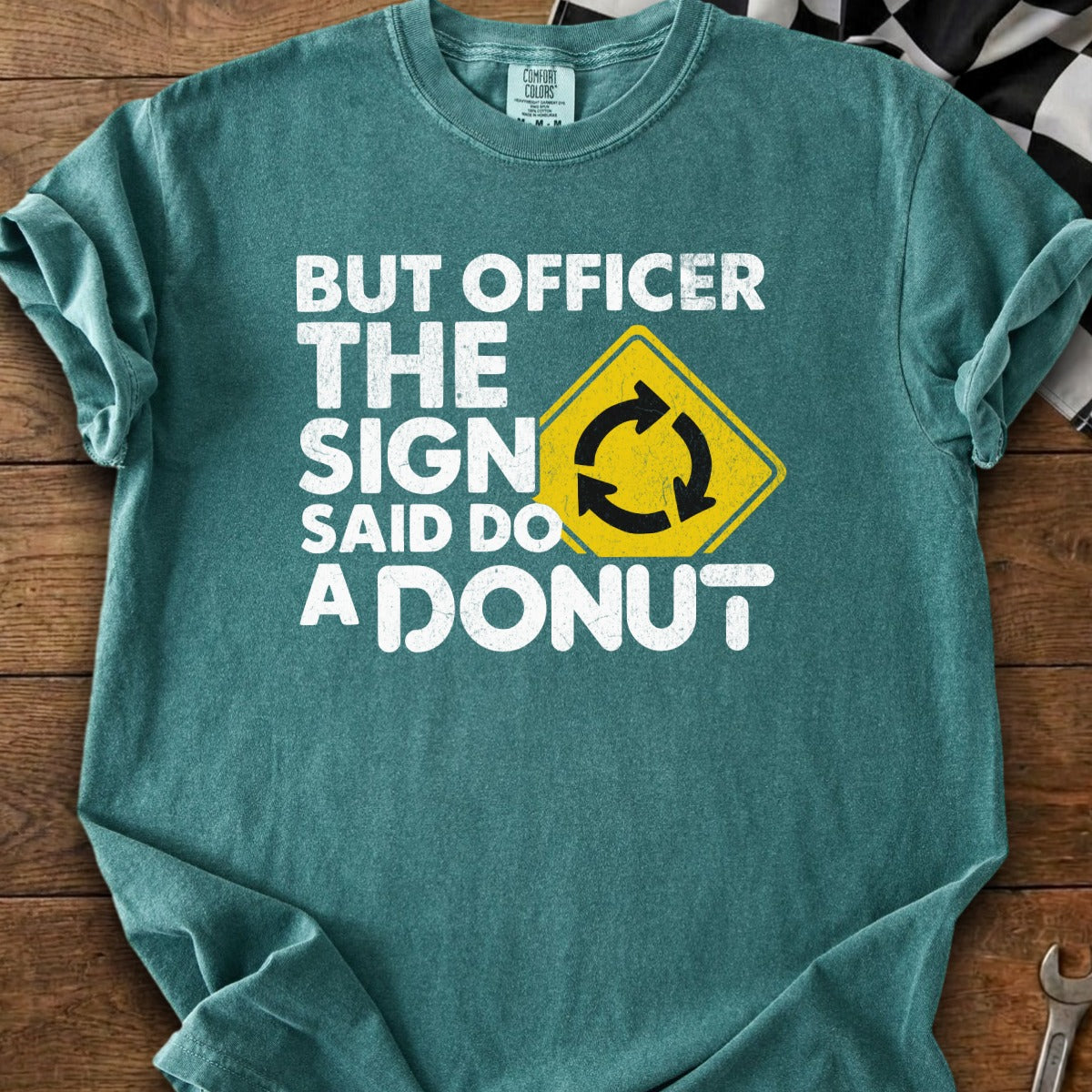 Teal t-shirt with "But Officer the sign said do a donut" text and roundabout symbol.