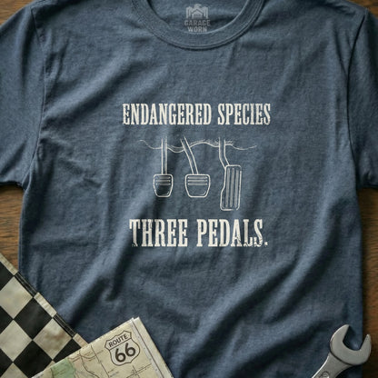 T-shirt with text "Endangered Species Three Pedals" over a checkered flag and map.