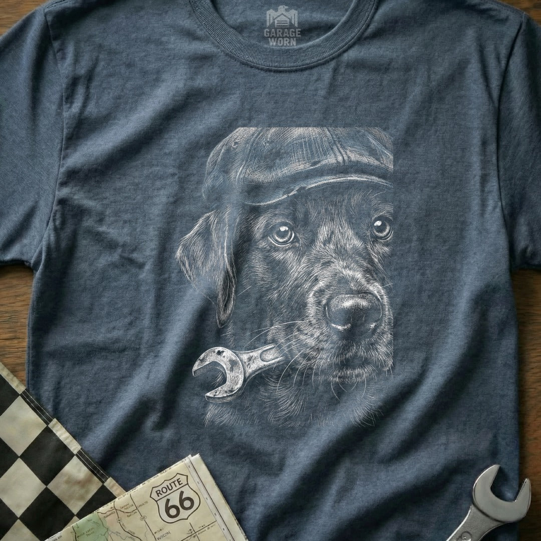 Dog wearing a cap and holding a wrench, charcoal sketch on a t-shirt.