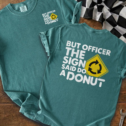 Teal t-shirt with white text and a yellow sign saying "But officer the sign said do a donut".